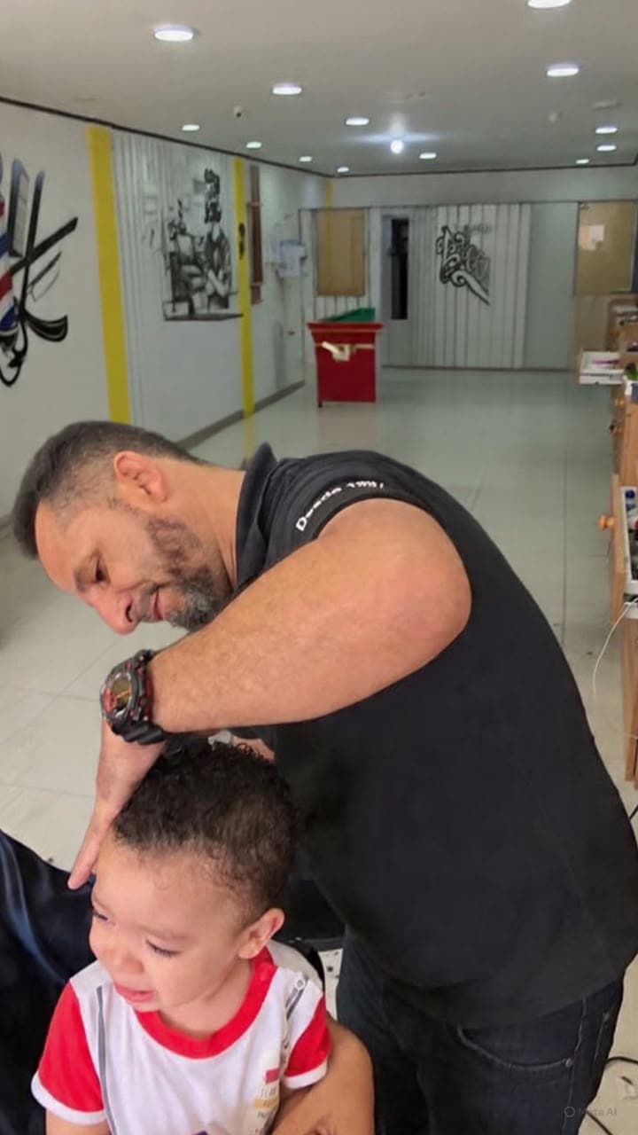 Raimundo cortando cabelo de criança com carinho