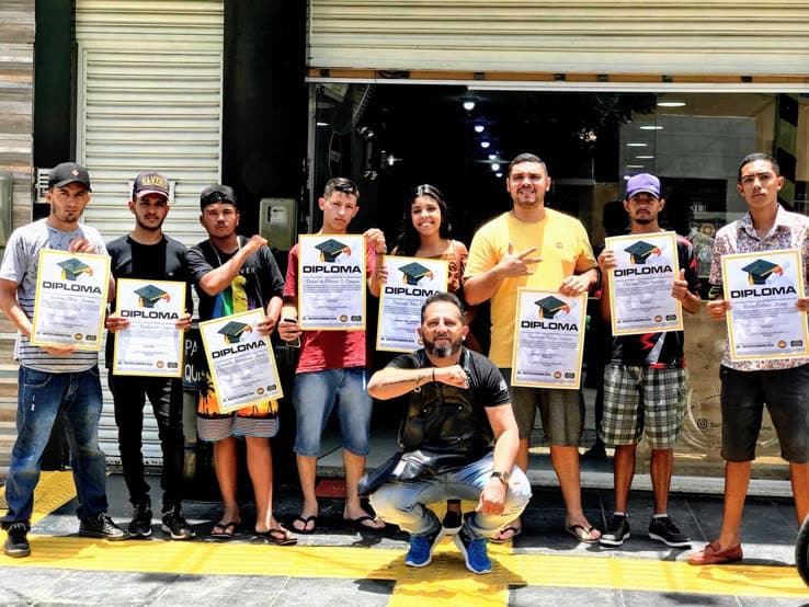 Turma de barbeiros exibindo os diplomas na fachada da Barbearia Executive