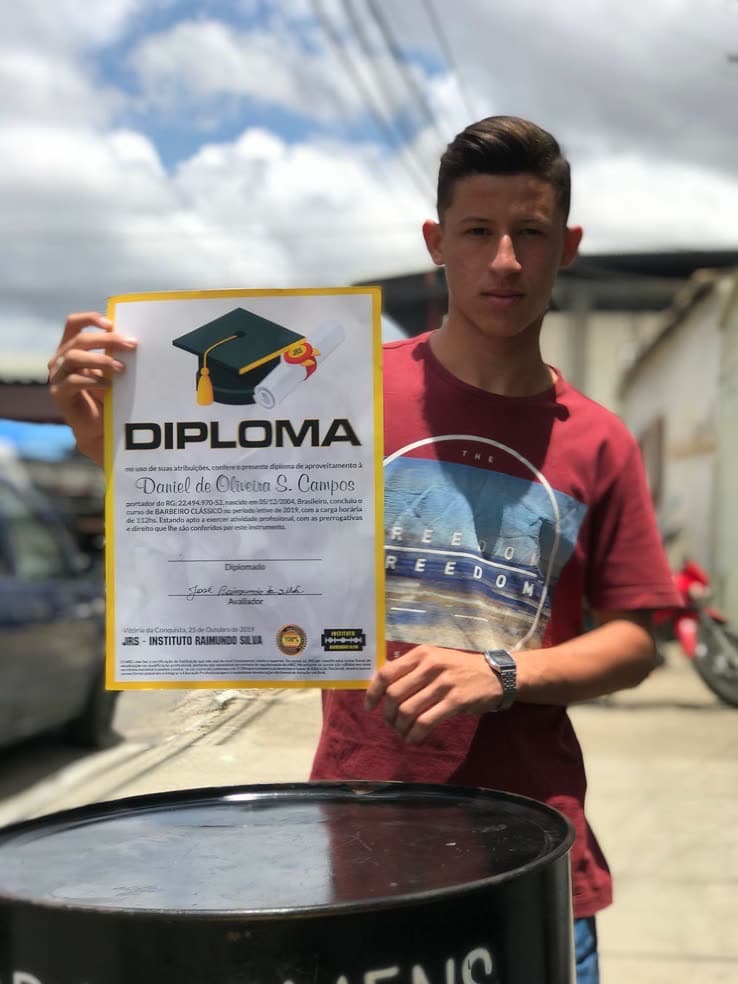 Aluno formado exibindo o diploma do Instituto Raimundo Silva